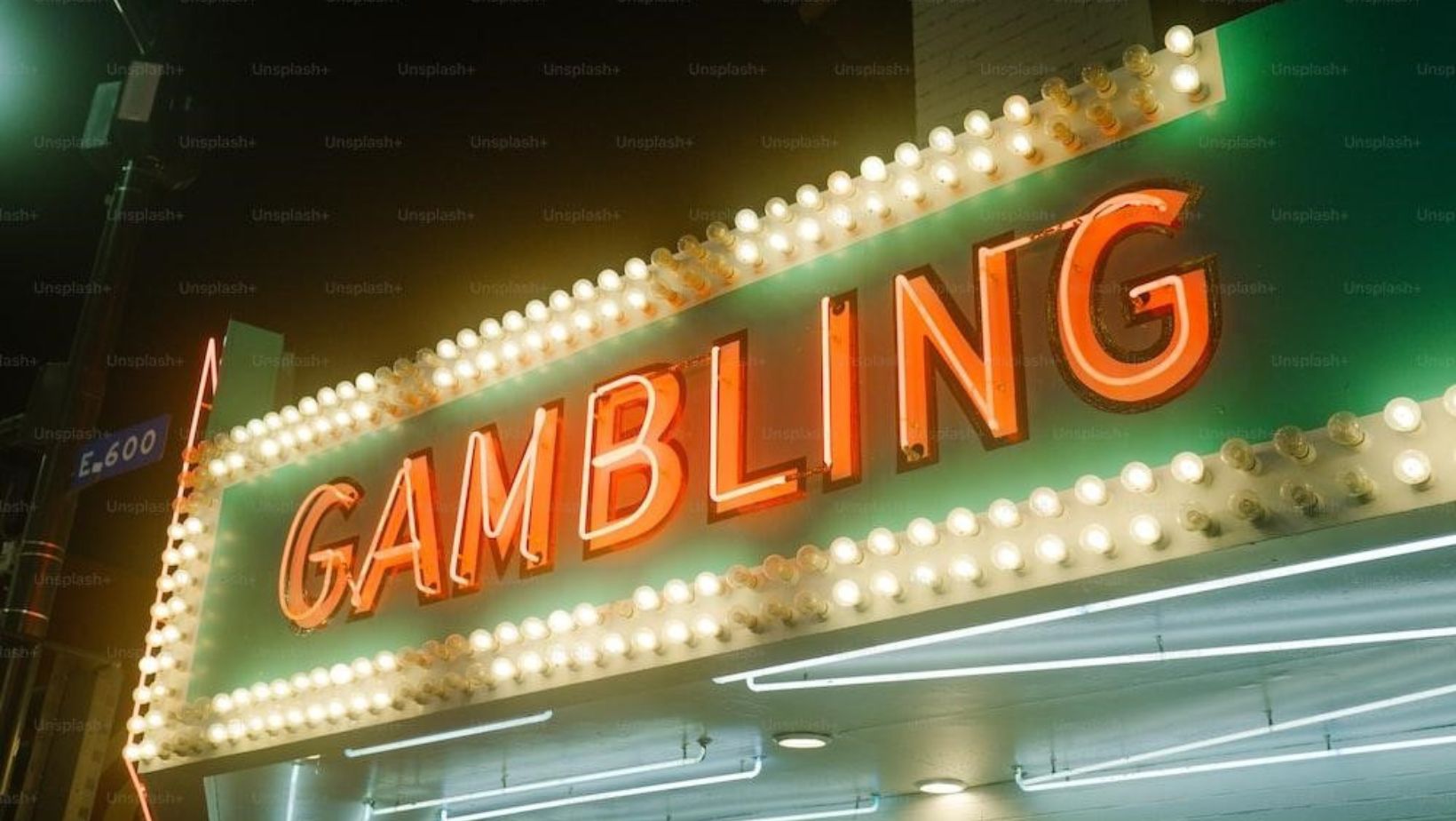 "Vibrant neon sign displaying the word 'Gambling' against a dark background