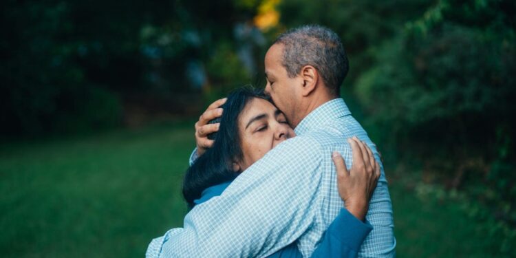 man hugging woman near trees